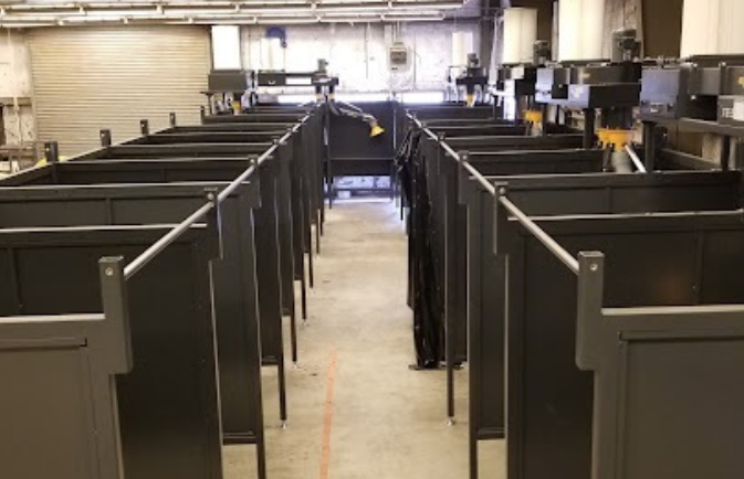 Welding booths and wall mounted fume extractors installed in a highschool workshop.