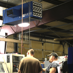 OX3500C ambient air cleaner removing black particulate from machine shop with CNC and welding equipment.