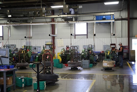 Strategic placement of a OX3500C air filtration unit directly over cold-header machines producing evaporated coolant mist.
