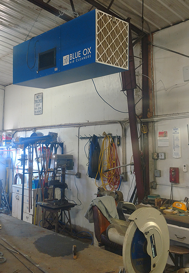 Small shop with a ceiling-mounted OX3000 air cleaner removing dangerous welding fumes